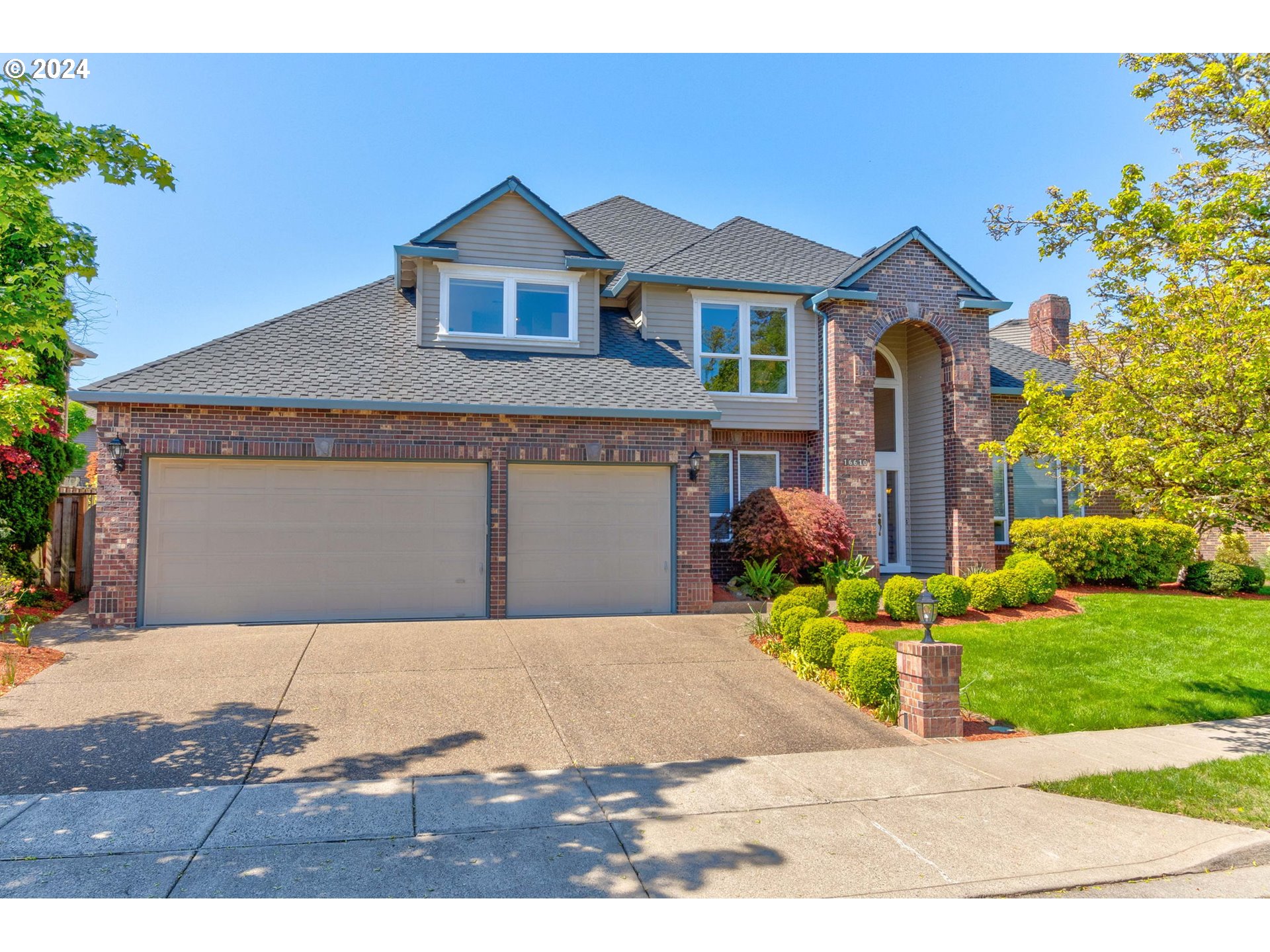 16610 Northwest Mission Oaks Drive Beaverton, OR 97006 - Photo 2 of 37 a front view of a house with a yard and garage