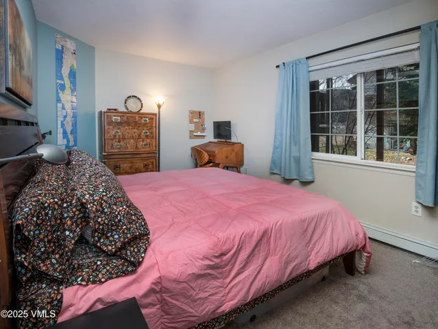a bedroom with a bed and dresser with mirror
