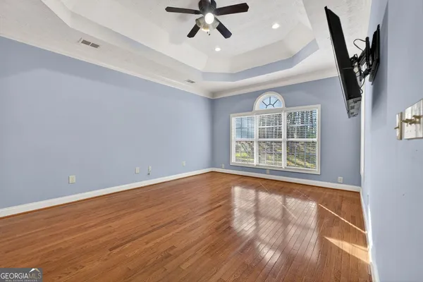 a view of an empty room with a window and wooden floor