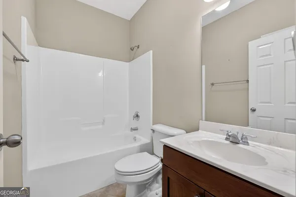 a bathroom with a granite countertop sink toilet a mirror and shower