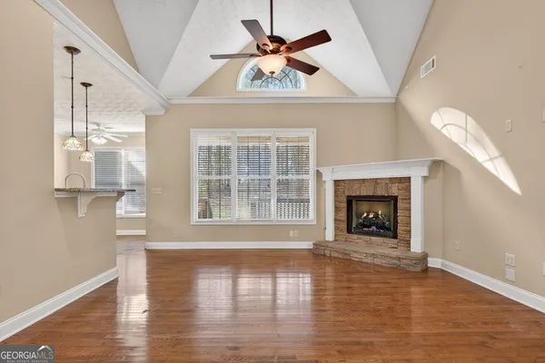 a view of an empty room with window and wooden floor