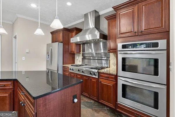 a kitchen with stainless steel appliances granite countertop a stove and a refrigerator