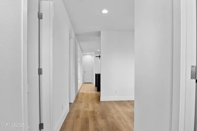 a view of a hallway with wooden floor