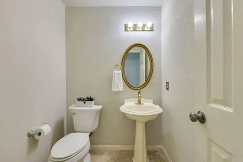 a bathroom with a sink toilet and a mirror