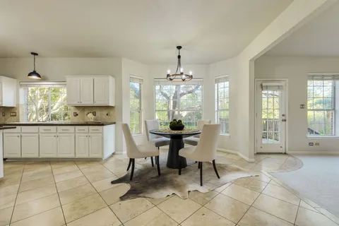a dining room filled a chandelier and kitchen view