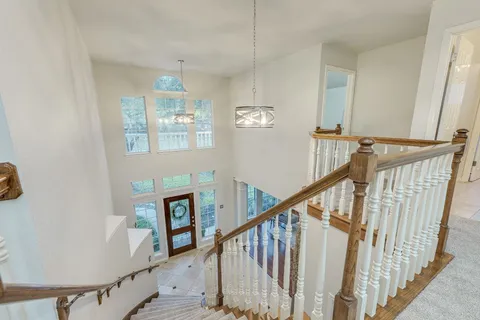 a view of staircase with lots of frames on wall and a window