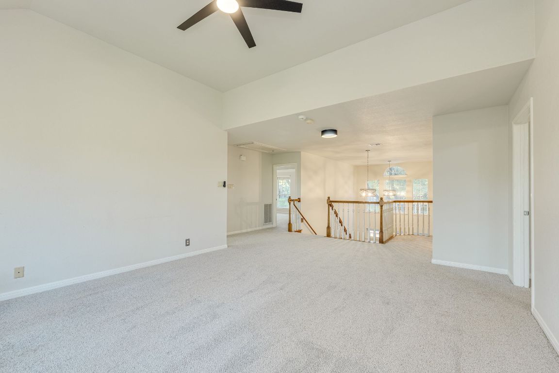 10701 Redmond Road Austin, TX 78739 - Photo 24 of 39 an empty room with chandelier fan and outdoor view