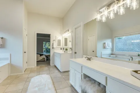 a spacious bathroom with a bathtub sink and a mirror