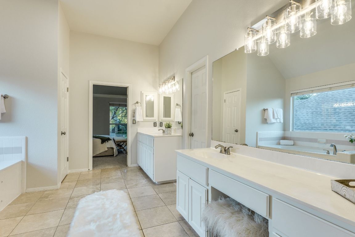 10701 Redmond Road Austin, TX 78739 - Photo 28 of 39 a spacious bathroom with a bathtub sink and a mirror