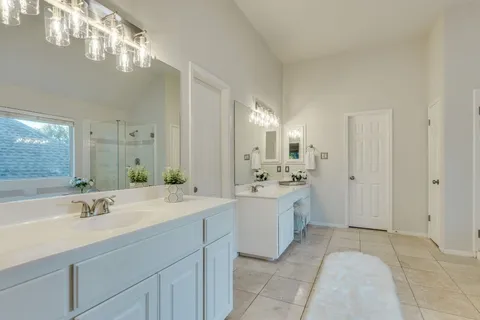 a spacious bathroom with a double vanity sink mirror and bathtub