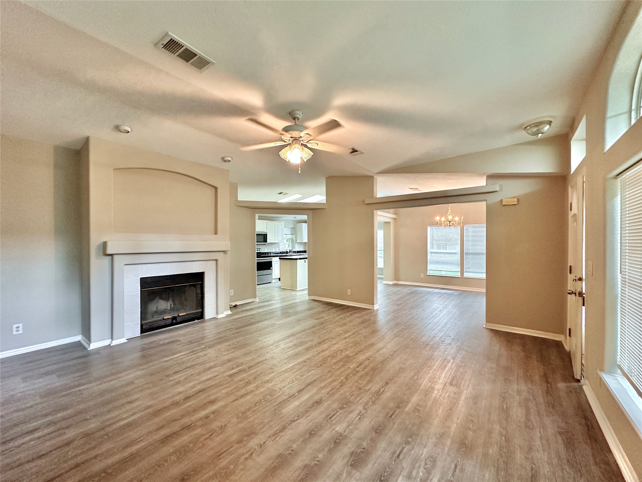 202 Main Street Fresno, TX 77545 - Photo 8 of 26 a view of an empty room with wooden floor fireplace and a window