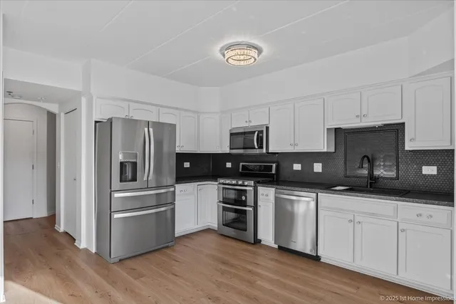 a kitchen with stainless steel appliances and white cabinets