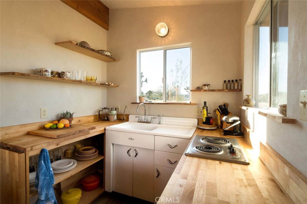 3535 Olympic Road Joshua Tree, CA 92252 - Photo 5 of 63 a view of a kitchen with a sink and a stove next to a window
