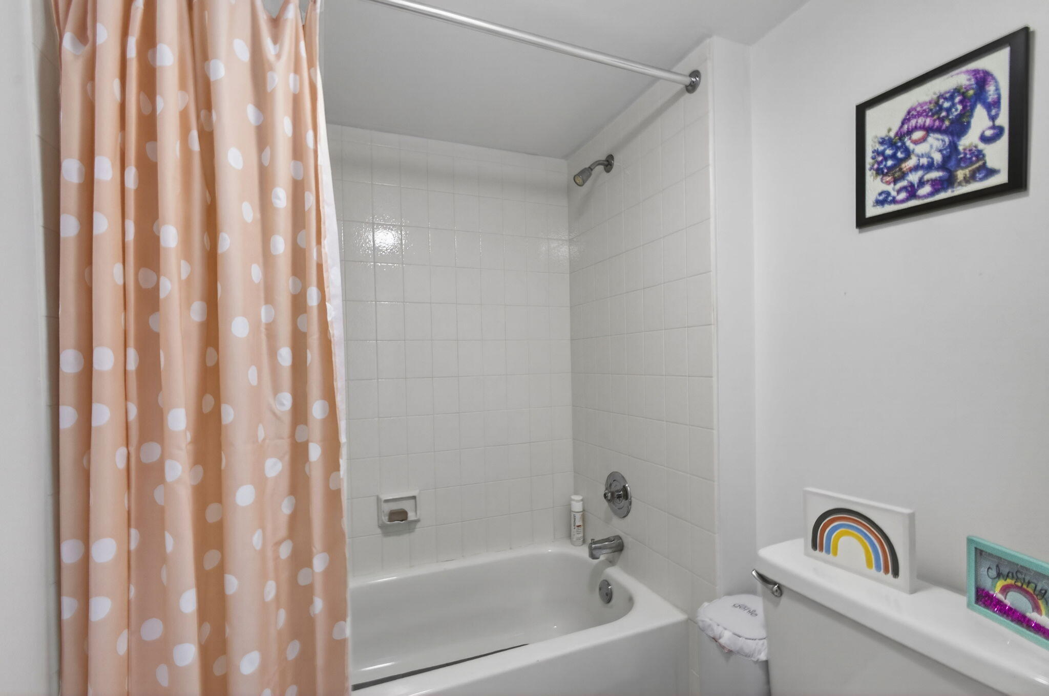 5680 Southeast Windsong Lane, Unit 345 Stuart, FL 34997 - Photo 38 of 54 a bathroom with a bathtub and a shower curtain