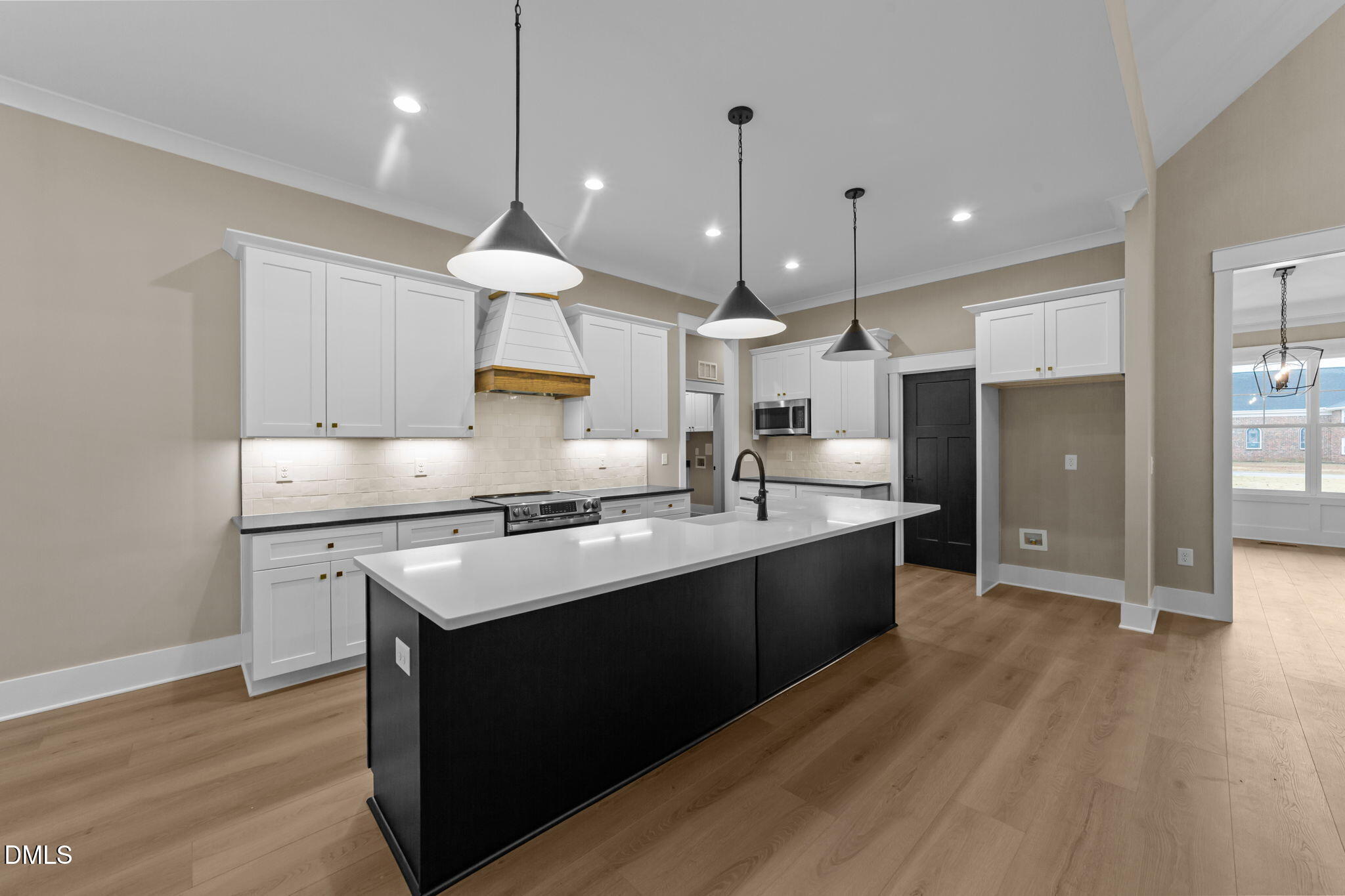 2590 Lassiter Road Four Oaks, NC 27524 - Photo 14 of 55 a kitchen with kitchen island a sink stainless steel appliances and wooden floor