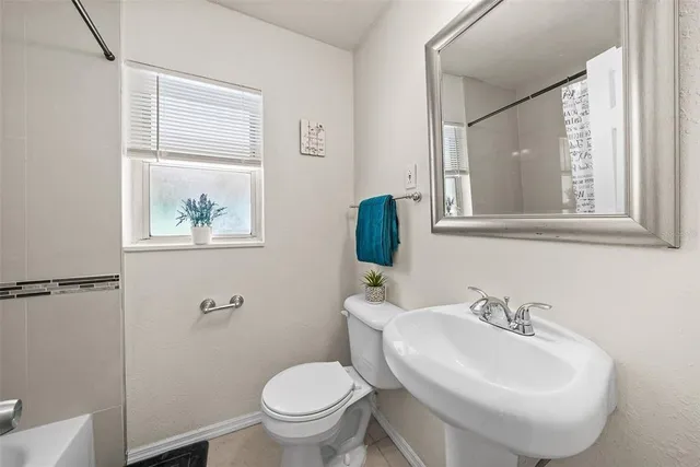 a bathroom with a sink mirror and toilet