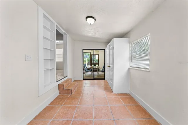 a view of an empty room with window and stairs