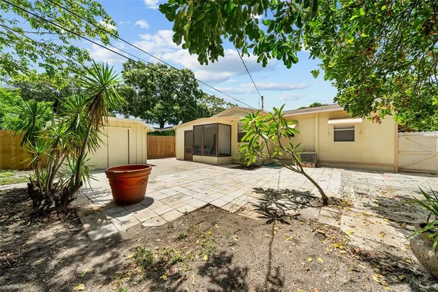 a potted plant sitting in front of a house with potted plants