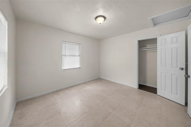 an empty room with windows and closet