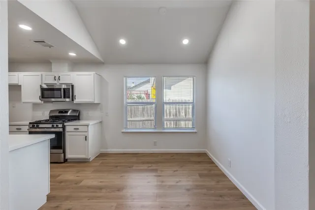 a kitchen with stainless steel appliances granite countertop a stove a sink and a refrigerator
