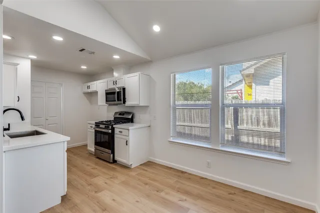 a kitchen with stainless steel appliances granite countertop a stove a sink a refrigerator and a microwave