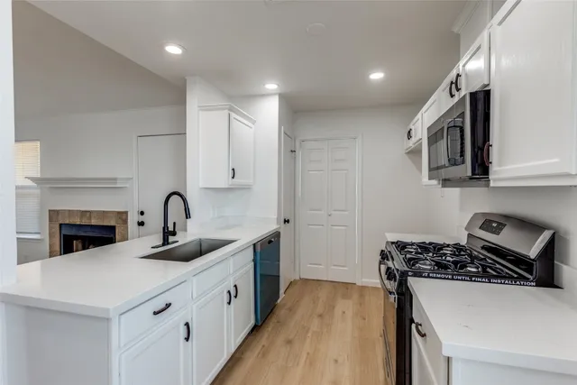 a kitchen with sink a stove and cabinets