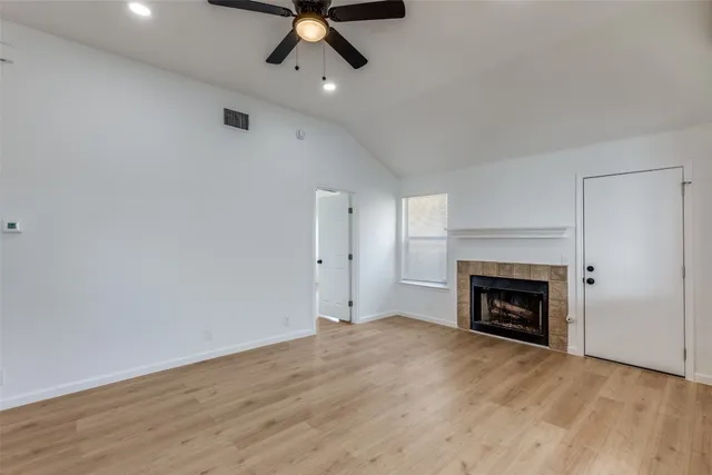 an empty room with ceiling fan and fireplace