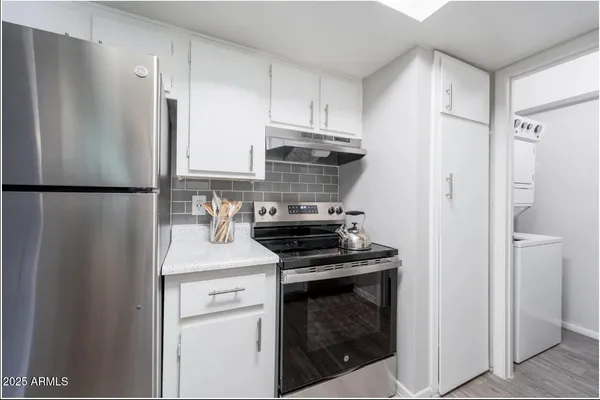 a kitchen with a refrigerator stove and white cabinets