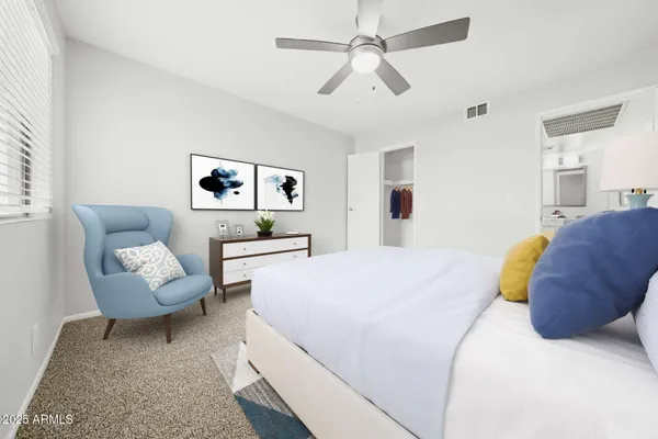 a spacious bedroom with a bed a couch and a chandelier