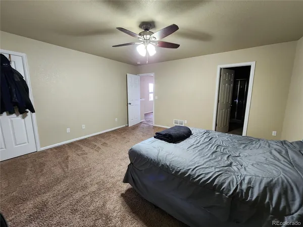 a bedroom with a bed and a ceiling fan