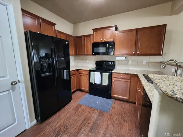 a kitchen with stainless steel appliances granite countertop a refrigerator stove and sink