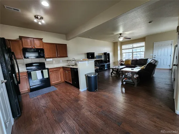 a kitchen with stainless steel appliances granite countertop wooden floors a stove and a sink