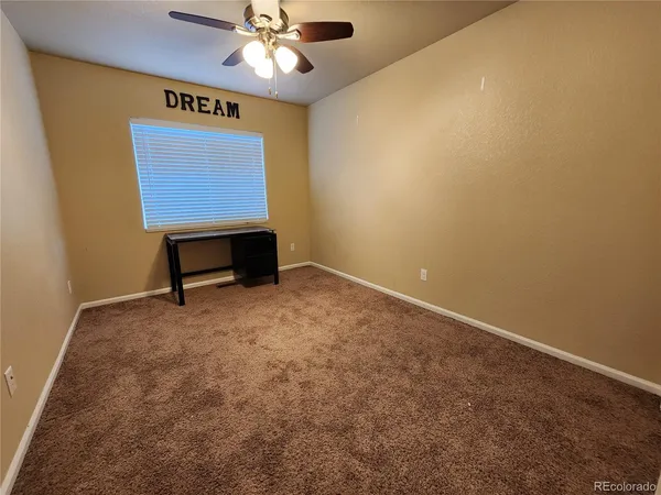 a view of room with a window and a ceiling fan