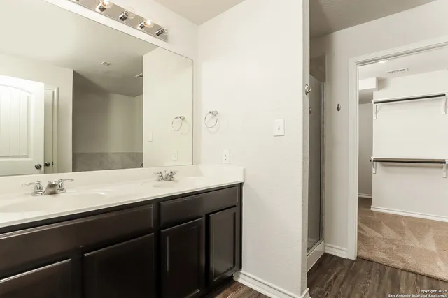 a bathroom with a double vanity sink and mirror