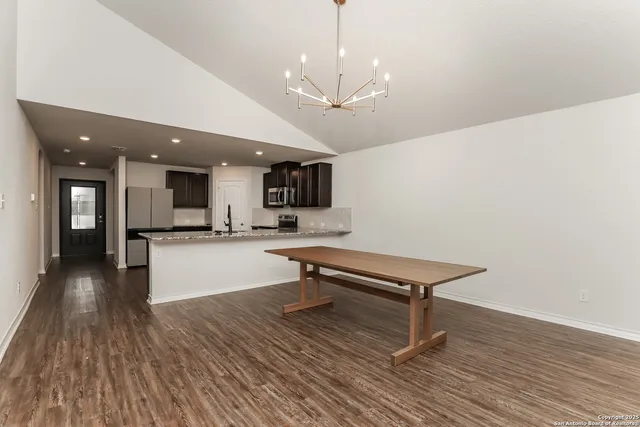 a living room with stainless steel appliances kitchen island hardwood floor and a kitchen view