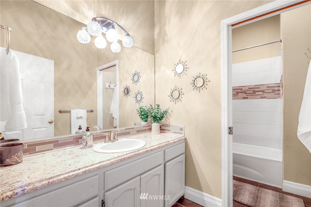 2287 East Hemmi Road Bellingham, WA 98226 - Photo 23 of 35 a bathroom with a granite countertop sink a mirror and a shower