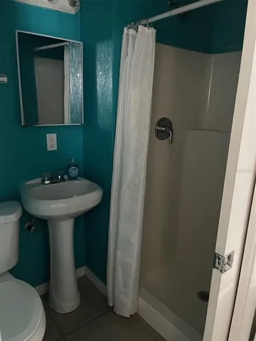a bathroom with a sink toilet and mirror