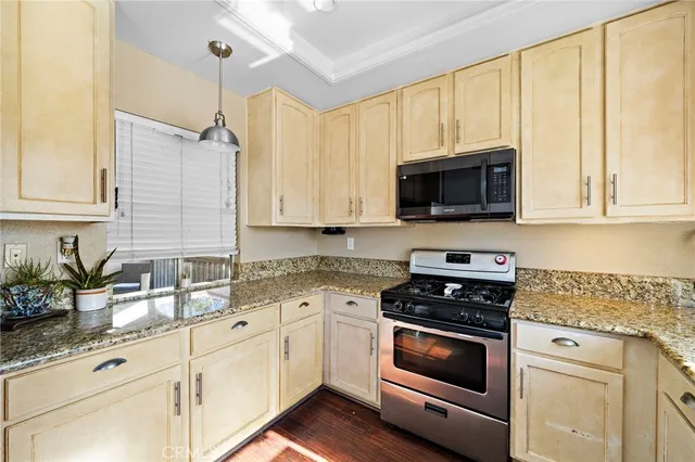 a kitchen with granite countertop white cabinets and white appliances