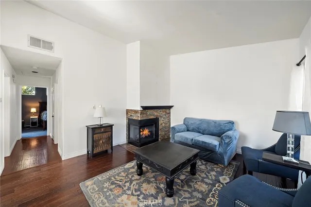 a living room with furniture a fireplace and wooden floor