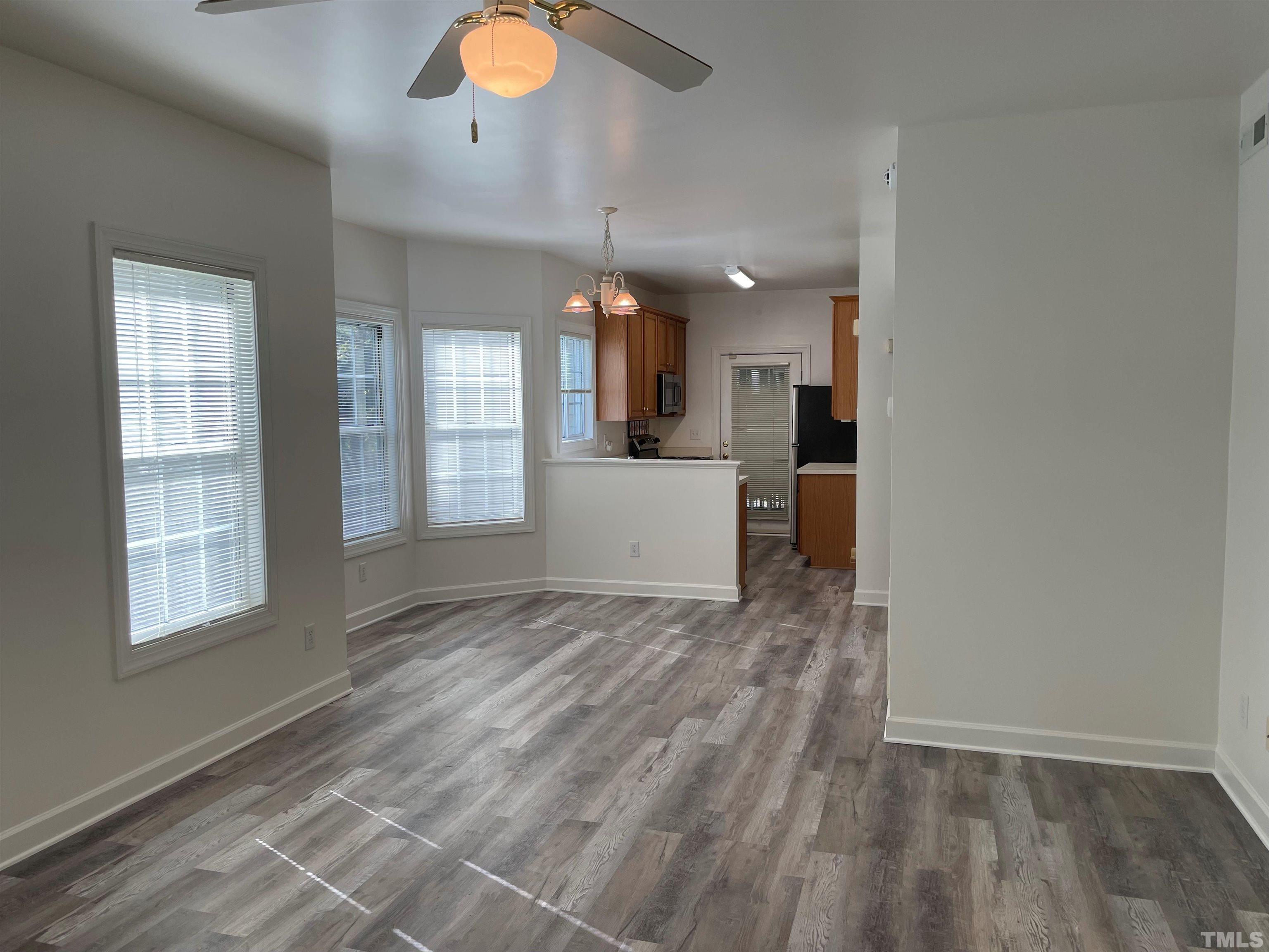 7018 Sandy Forks Road, Unit 202 Raleigh, NC 27615 - Photo 5 of 22 an empty room with wooden floor and windows