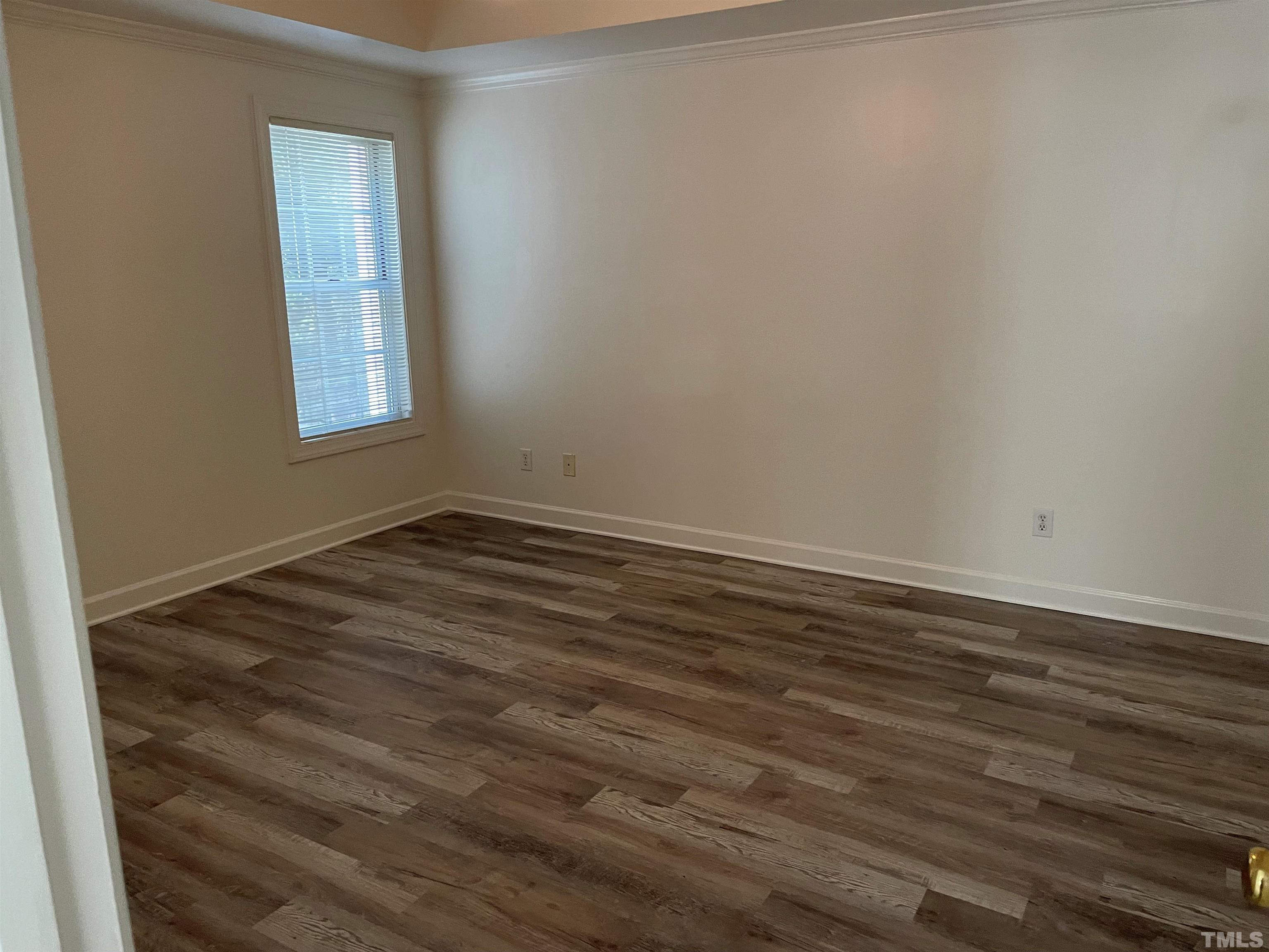 7018 Sandy Forks Road, Unit 202 Raleigh, NC 27615 - Photo 8 of 22 a view of an empty room with wooden floor and a window