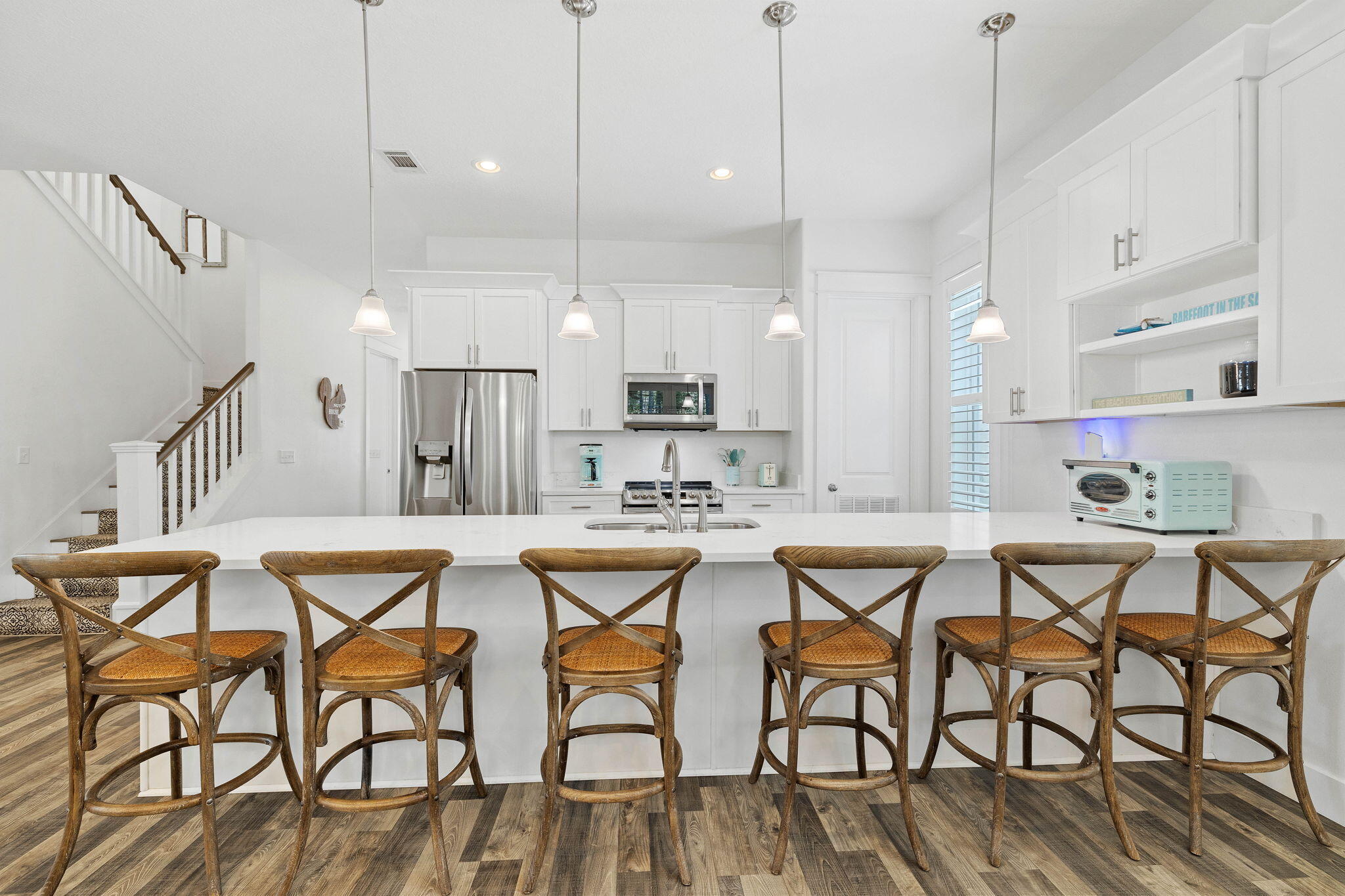 a dinning area with stainless steel appliances kitchen island granite countertop furniture and a wooden floor