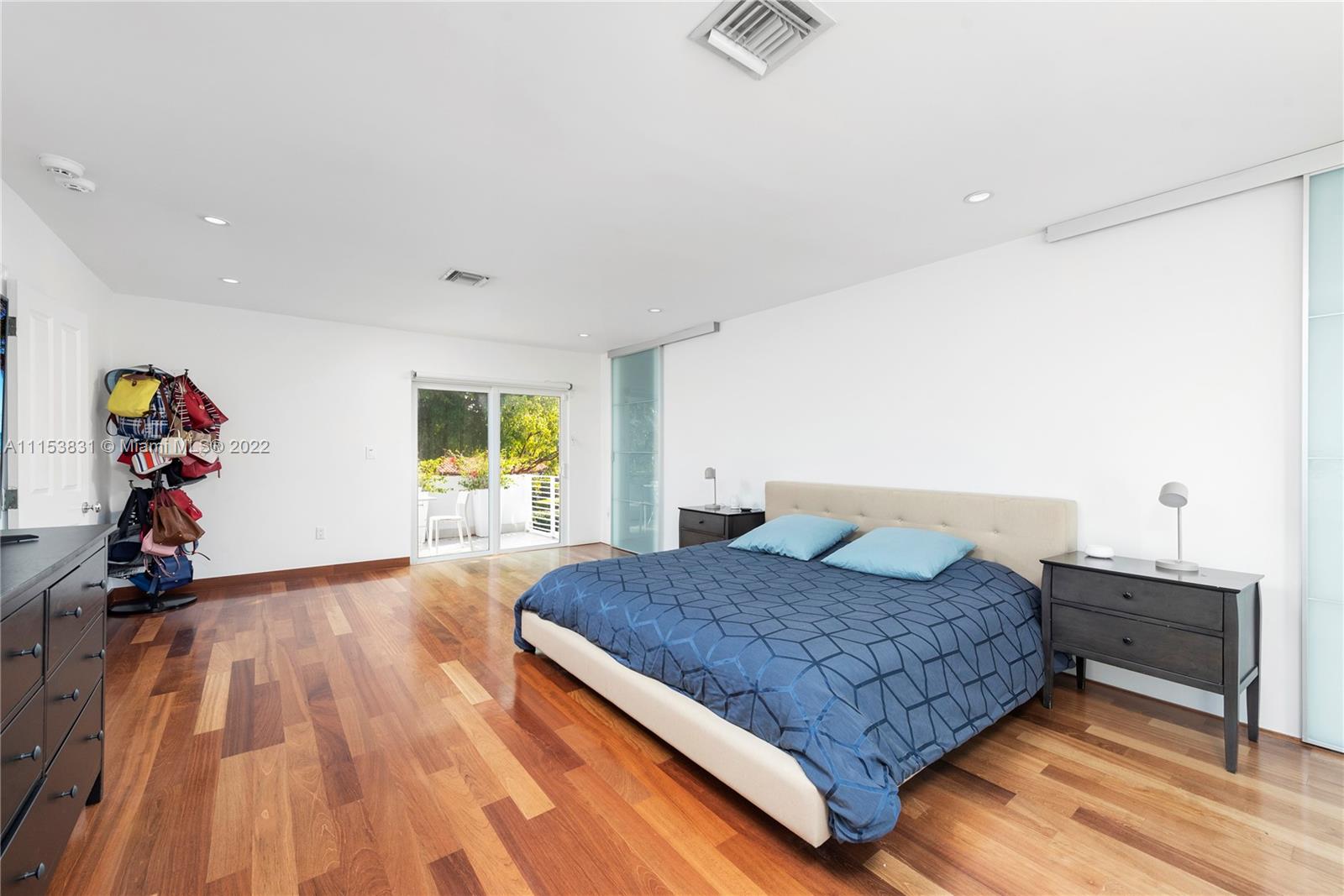 260 Ridgewood Road Key Biscayne, FL 33149 - Photo 17 of 41 a bedroom with a bed and wooden floor