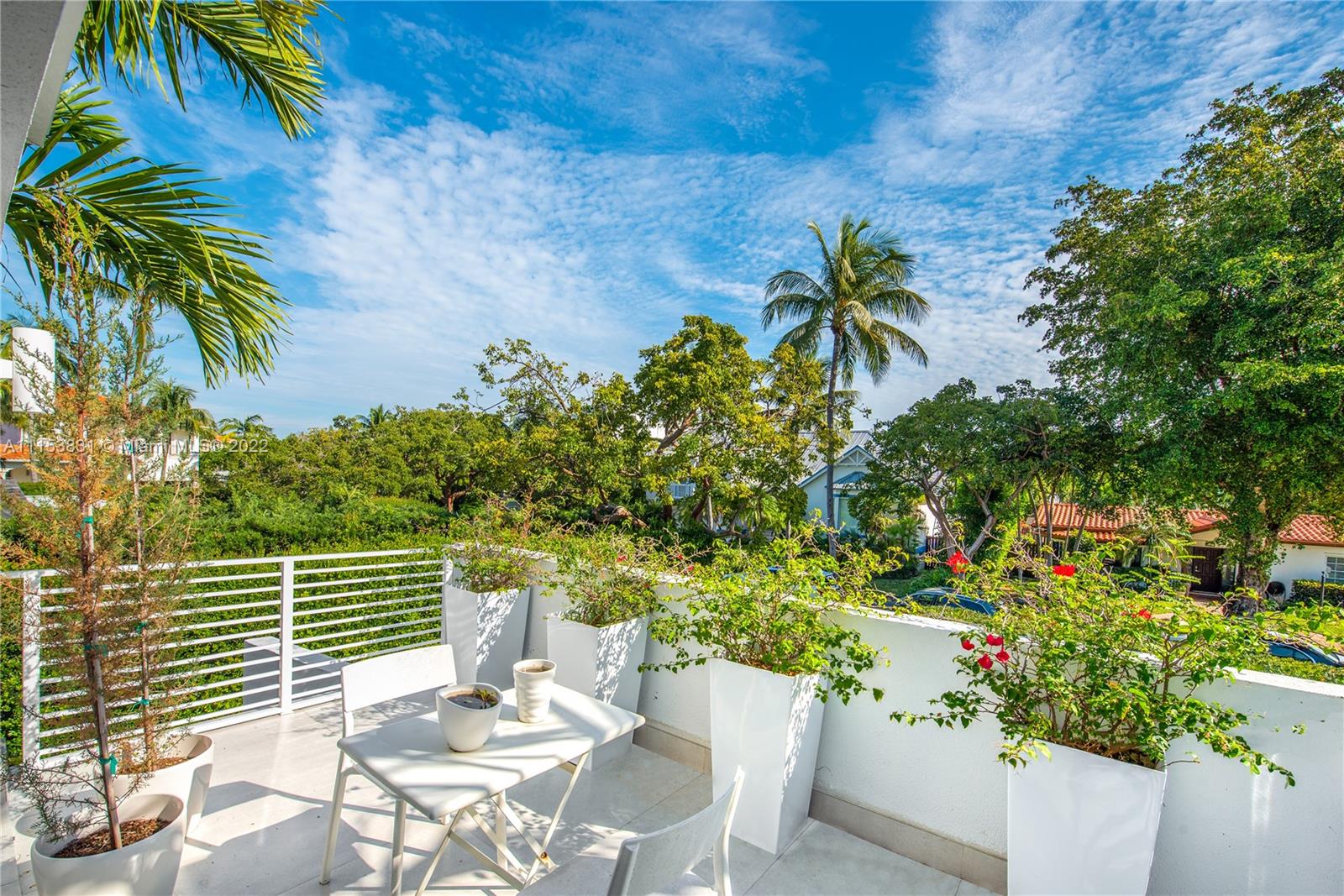 260 Ridgewood Road Key Biscayne, FL 33149 - Photo 21 of 41 a view of a balcony with a table and chairs
