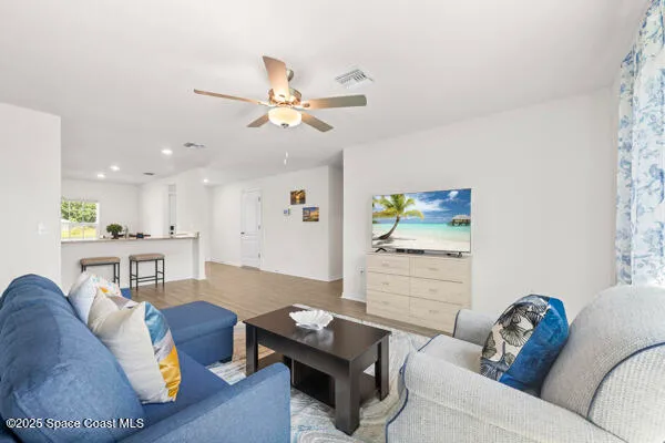 a living room with furniture and a wooden floor