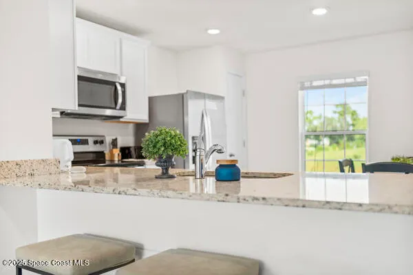 a kitchen with granite countertop a sink and a stove top oven