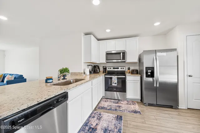 a kitchen with a sink stainless steel appliances and counter space