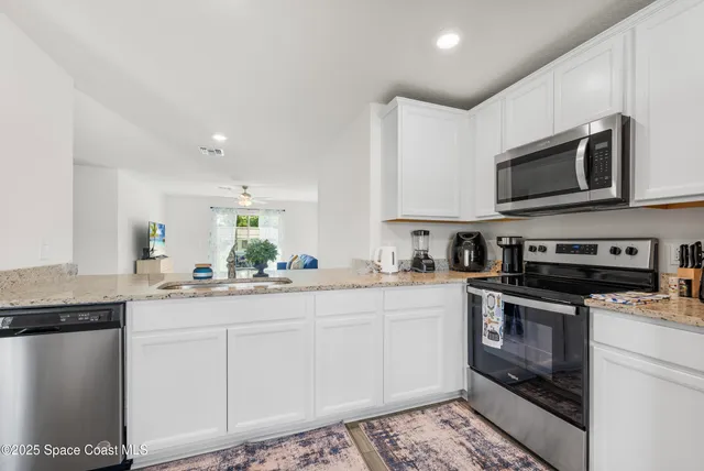 a kitchen with stainless steel appliances granite countertop a stove a sink and a microwave