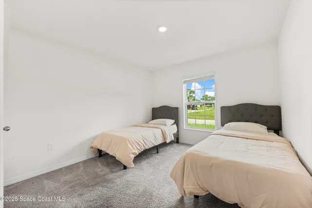 a bedroom with two beds and a window