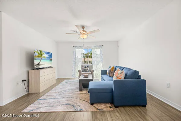 a living room with furniture and a wooden floor